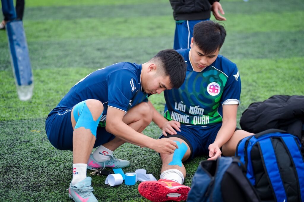 players strapping up knee from injury