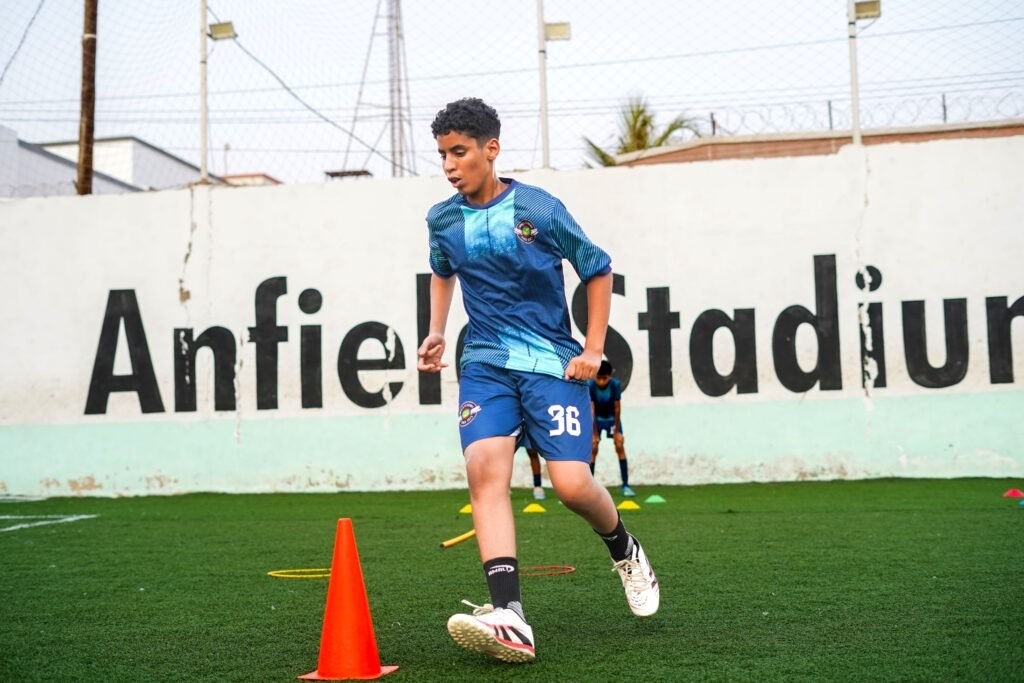 footballer running between cones
