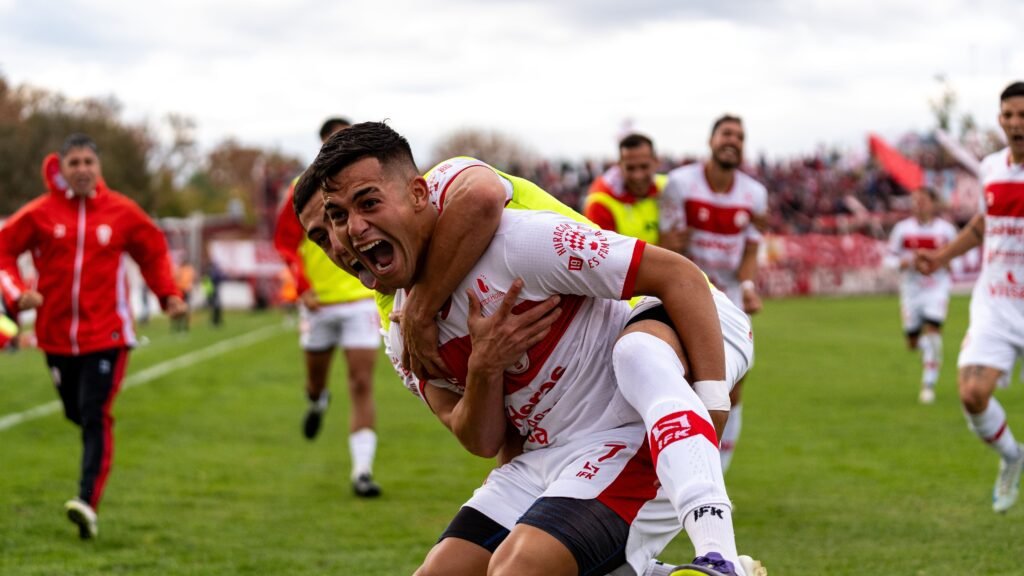 soccer players celebrate scoring a goal
