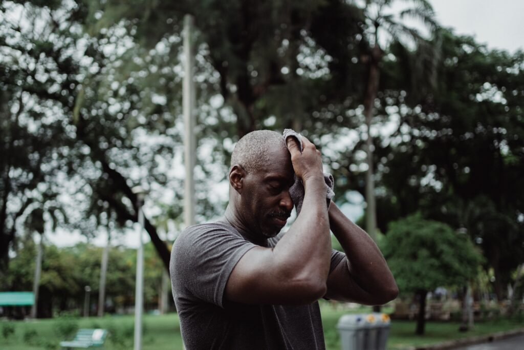 man wiping sweat off his forehead